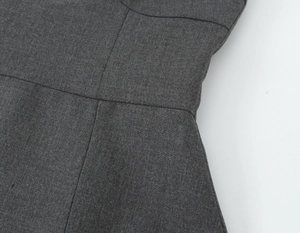 Détail de la couture latérale renforcée sur le tissu gris foncé de cette robe courte