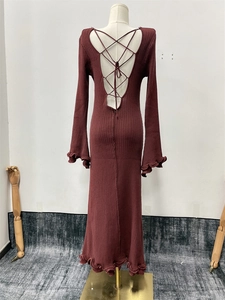 Detail of burgundy knitted dress featuring a backless cross-tie design and ruffled edges