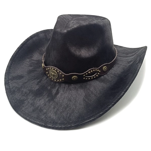 Detail of black cowboy hat with brown leather band and bull head metal emblem decoration