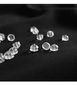 Macro shot of bulk transparent silicone bullet earring backs on black background