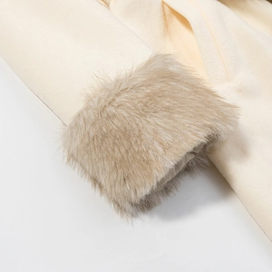 Gros plan du poignet en fausse fourrure sur un manteau en laine suédée beige