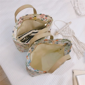 Top view of floral canvas tote bags with leather handles and smooth zipper closure