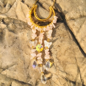Detailed shot of golden moon suncatcher with pink crystals and clear butterfly beads