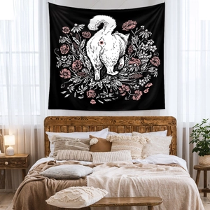 Detail view of cat tapestry with white kitten and pink flowers over a bedroom bed