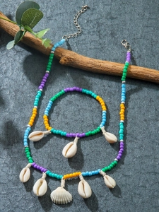 Flat lay of colorful beaded necklace and bracelet set with natural white seashells