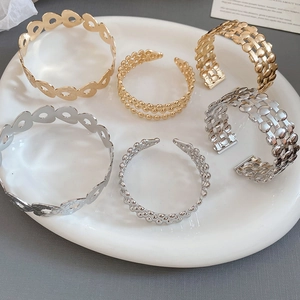Close-up of a six-piece set of gold and silver plated hollow and beaded bangles