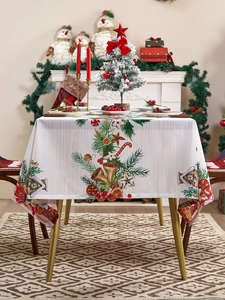 Detalle de la textura de tela de mantel navideño blanco con piñas y motivos de campanas