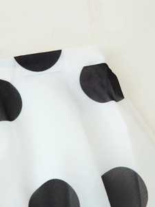Nahaufnahme von weißem Polka-Dot-Stoff mit feinen Nähten am Hosenbund der Sets