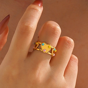 Bague cœur minimaliste plaquée or avec points émail colorés portée sur le doigt