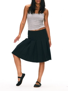 Full view of black pleated midi skirt styled with grey vest and ballet flats