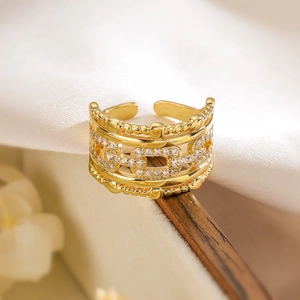 Detailed view of hollow geometric gold ring with cubic zirconia on a wooden surface