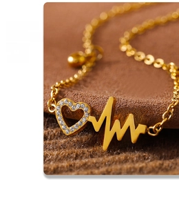 Macro shot of gold heartbeat anklet with heart-shaped pendant and white zircon inlay details