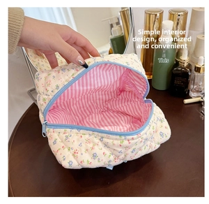 Detail view of the spacious inner compartment with pink striped lining and blue zipper closure