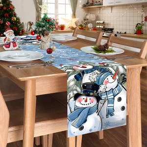 Christmas table runner featuring blue snow scene with three snowmen on a wooden table