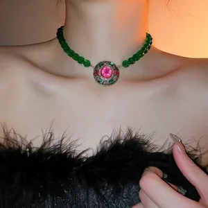 Vintage emerald green beaded necklace with pink gemstone pendant on female model