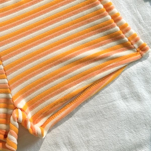 Detailed view of the orange striped terry cloth fabric with high-quality stitching