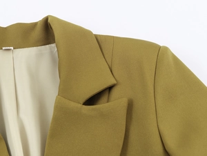 Close-up of olive green blazer collar showing neat stitching and beige lining detail