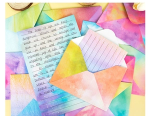 Close-up of watercolor stationery set featuring colorful gradient envelopes and lined paper