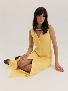 Détail de la maille côtelée jaune et de la fermeture à boutons sur robe sans manches col V
