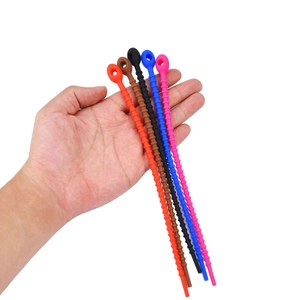 Detailed view of flexible colorful silicone cable ties held by hand for scale and grip