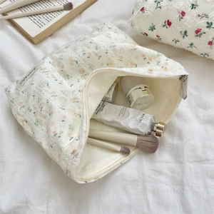 Detailed macro view of cream floral cosmetic bag featuring lace trim and vintage fabric