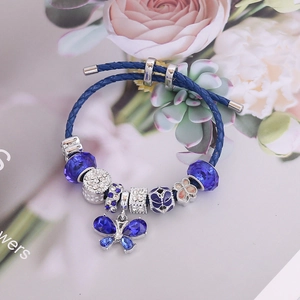 Detailed shot of blue braided leather bracelet with crystal butterfly charm and silver beads