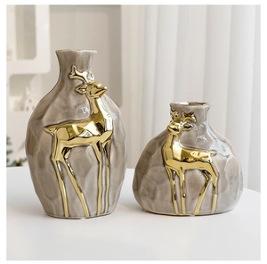 Close-up of grey ceramic vases with gold reindeer accents for Christmas decor