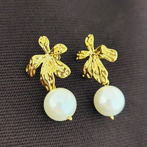 Minimalist golden leaf pearl drop earrings with textured metal and elegant design