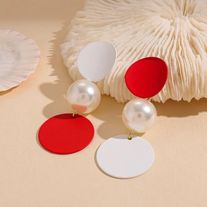 Asymmetric red and white geometric pearl drop earrings on beach theme background