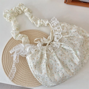 Detail of floral tote bag with lace trim, bow tie, and gathered scrunchie strap