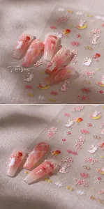 Macro shot of nail stickers featuring pink cherry blossoms, golden clouds and rabbits