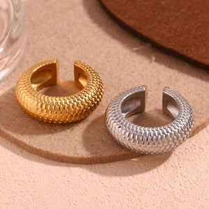 Detailed macro view of 18K gold and silver earrings with textured fish scale pattern