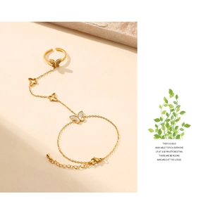Detail of 18K gold butterfly slave bracelet with white shell inlay and finger ring set
