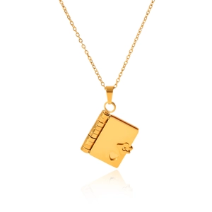 Macro shot of an openable golden book-shaped locket necklace with a heart pattern