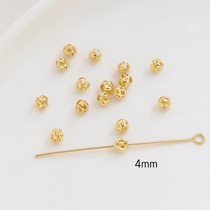 Macro detail of 4mm gold hollow spacer bead on T-pin for DIY jewelry making