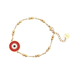 Macro detail of golden stainless steel ball chain bracelet with red evil eye charm