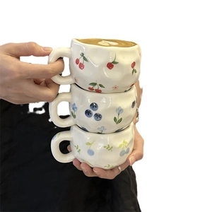 Hand-painted ceramic coffee mugs with fruit patterns and irregular handmade shape