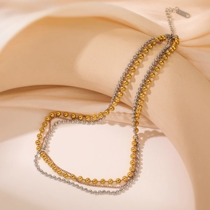 Collana a strati con perle oro e argento su seta beige con elegante lucentezza metallica