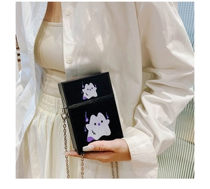 Detail of black box crossbody bag featuring a cute purple ghost print and silver chain