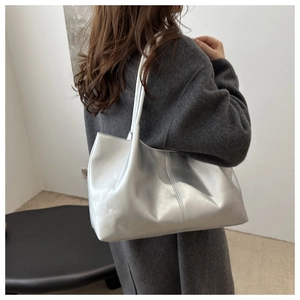 Silver metallic tote bag shown on a model wearing a grey wool coat for daily style