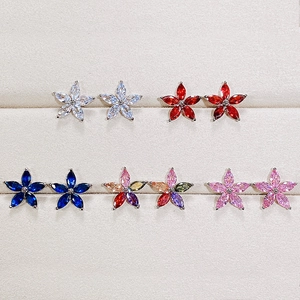 Macro shot of colorful floral stud earrings with sparkling crystals in a velvet tray