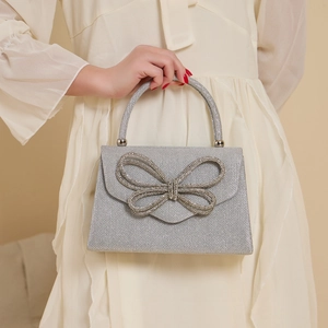 Elegant silver evening bag with sparkling rhinestone bow and top handle for weddings