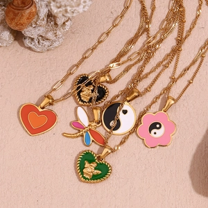 Flat lay of colorful enamel heart and dragonfly pendants on 18K gold plated chains