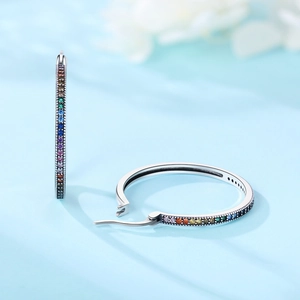 Boucles d'oreilles créoles argentées avec cristaux arc-en-ciel vus de deux angles