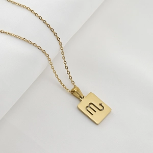 Macro shot of 18K gold plated Scorpio zodiac square pendant on stainless steel chain