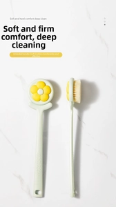 Detail of mint green long handle bath brush with floral pattern and soft white bristles