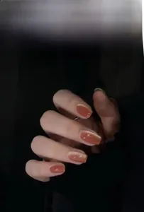 Detailed view of amber cat eye press-on nails with glossy finish on hands