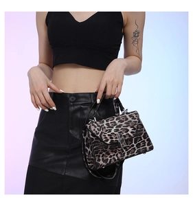 Detail of leopard print handbag with silver rectangular buckle and sturdy top handle
