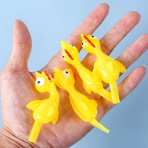 Set of four yellow TPR slingshot chicken toys held in a hand against a blue background