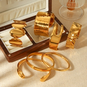 Polished and hammered golden stainless steel bangles set on a premium display